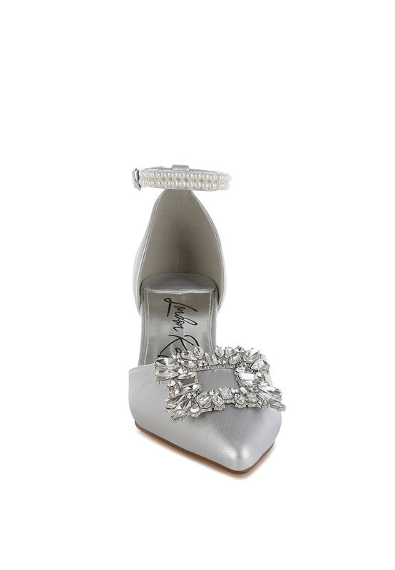 Silver kitten-heel sandal front view with rhinestone brooch and beaded strap