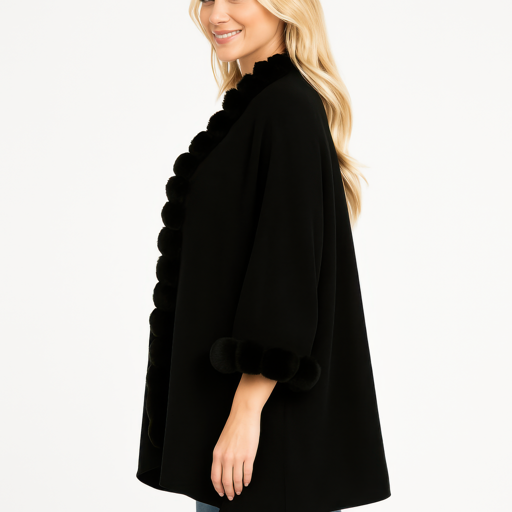 Black open-front cape side view with pom faux fur trim at cuffs