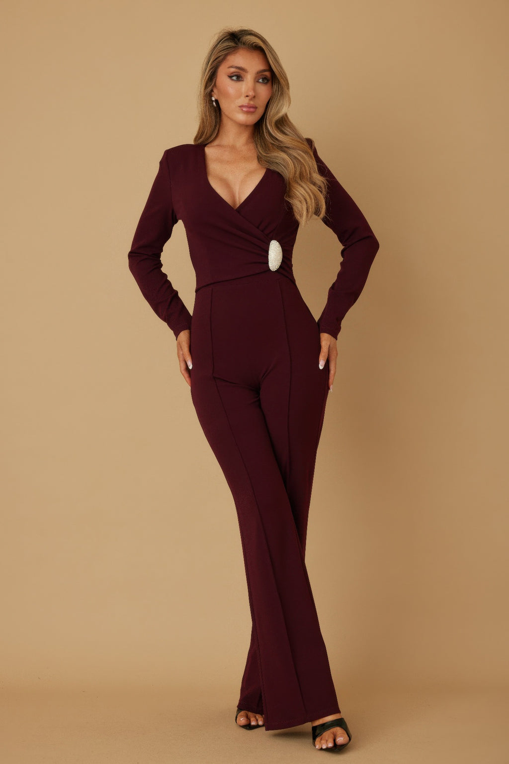 Wine wrap jumpsuit with long sleeves, V-neck, oval crystal belt accent, wide legs.