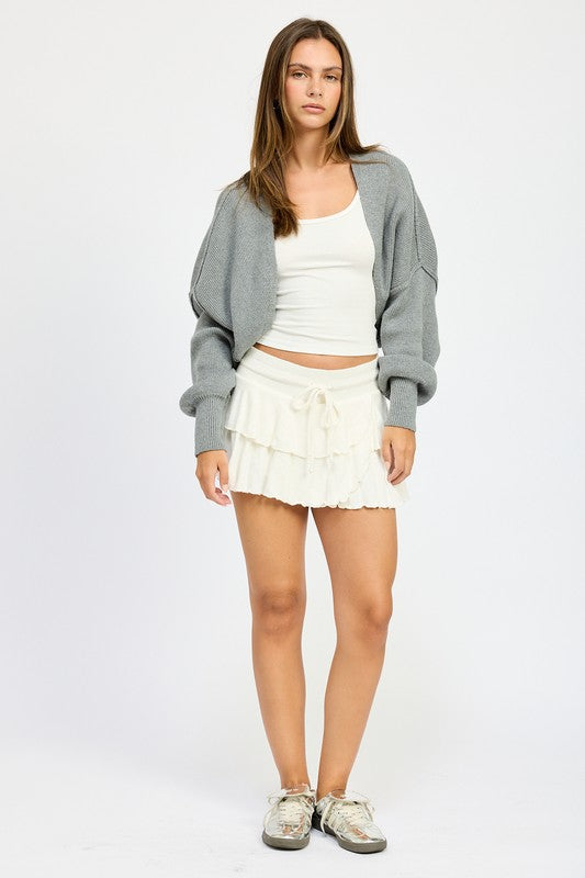 Dark gray oversized shrug cardigan worn open, relaxed fit with long sleeves