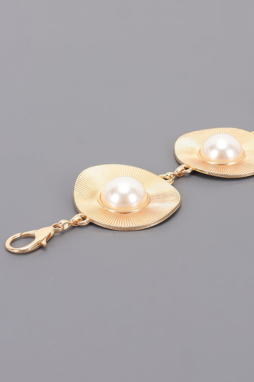 Gold pearl accent disc chain belt close-up: two textured discs with pearl centers