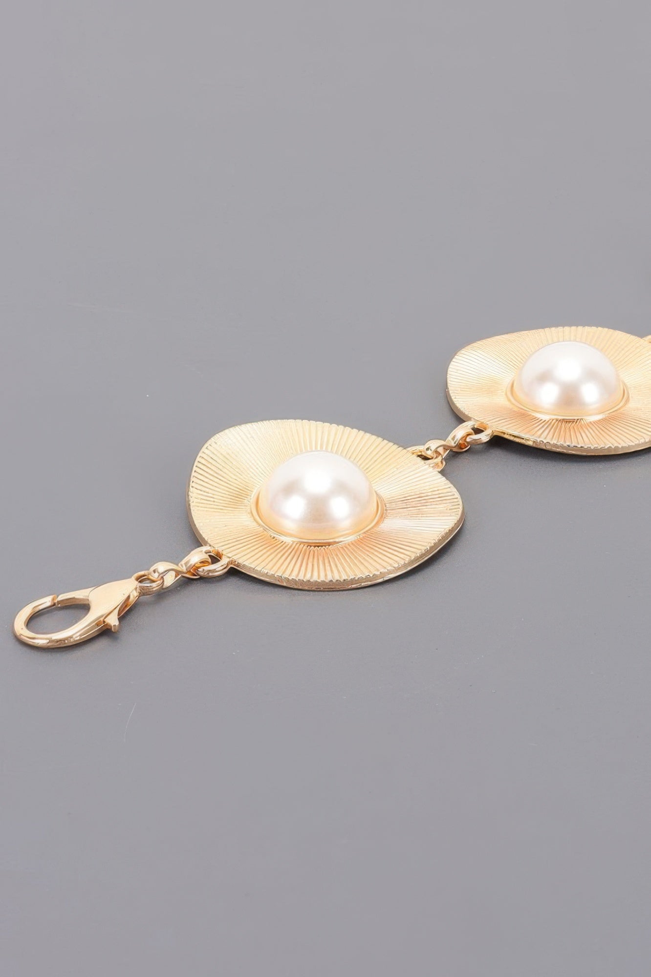 Gold pearl accent disc chain belt close-up: two textured discs with pearl centers
