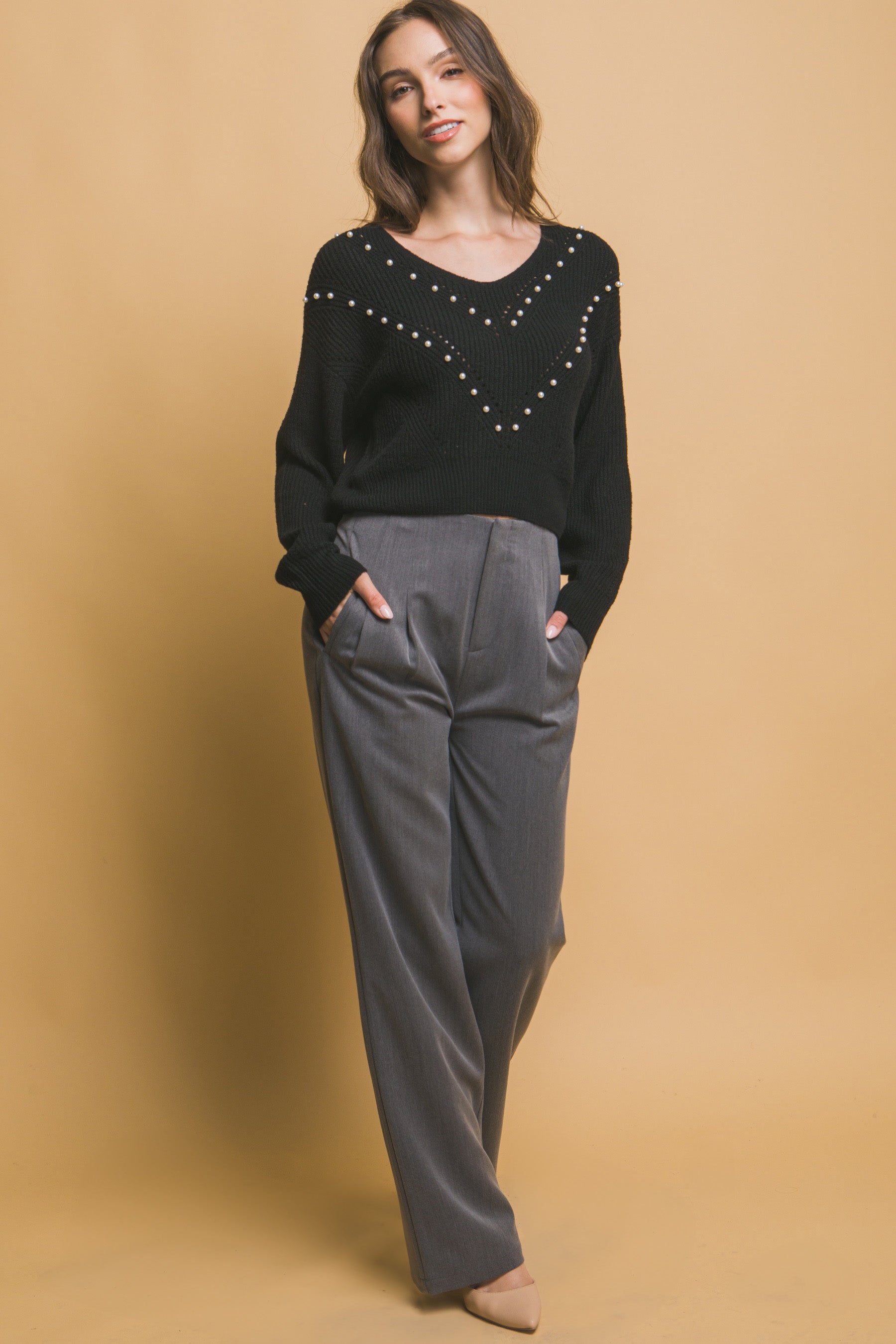 Black knit sweater with pearl beading V-neck and long sleeves, full-body view