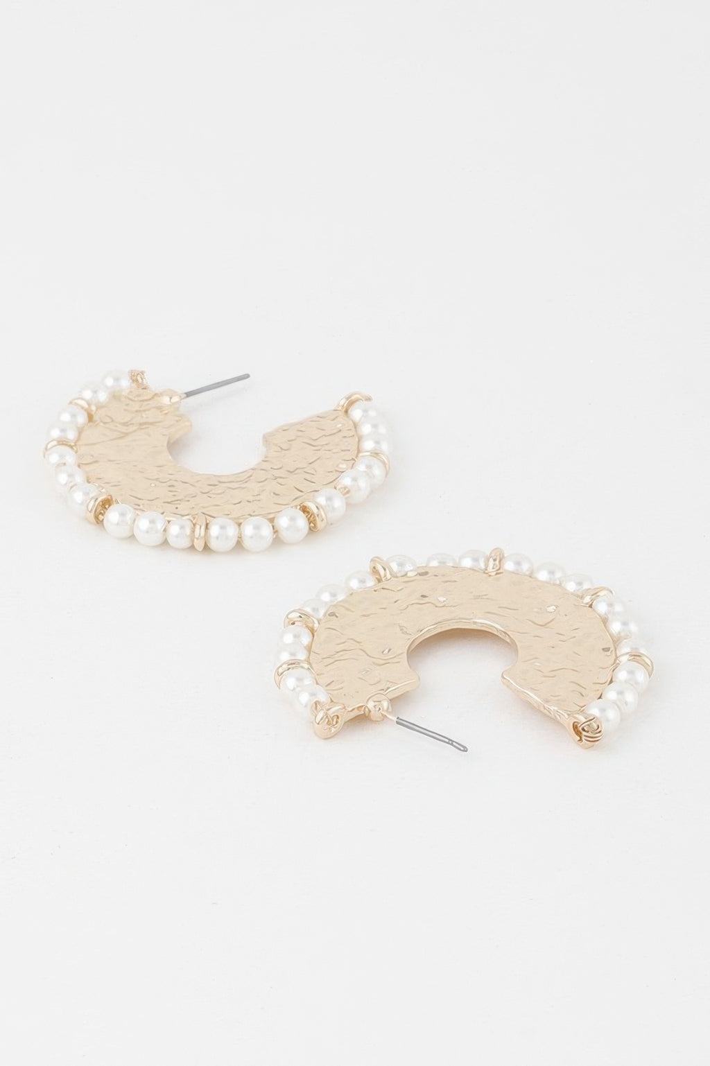 Close-up: pearl beaded hammered hoop earring with gold hook and cutout center