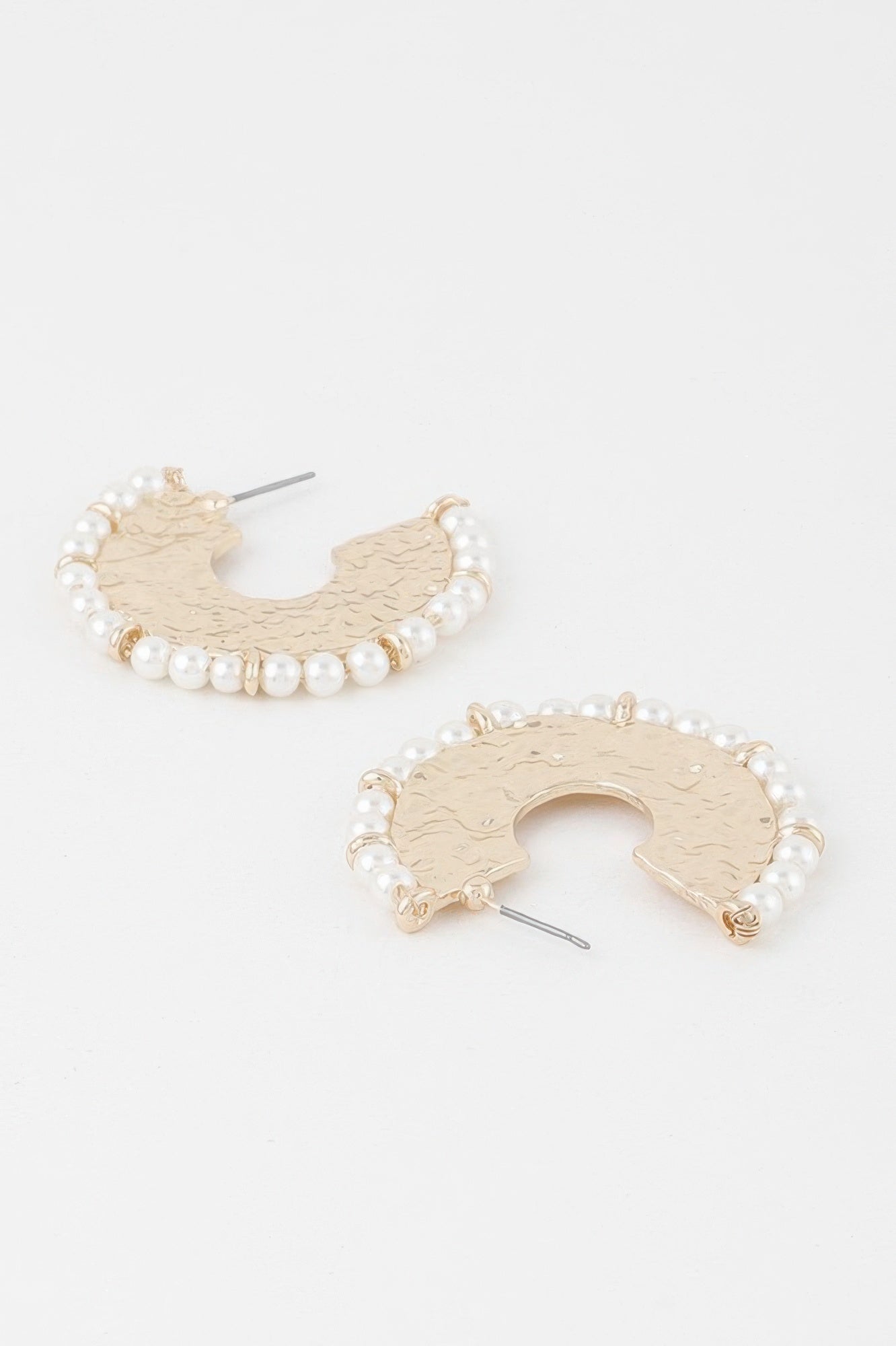 Close-up: pearl beaded hammered hoop earring with gold hook and cutout center