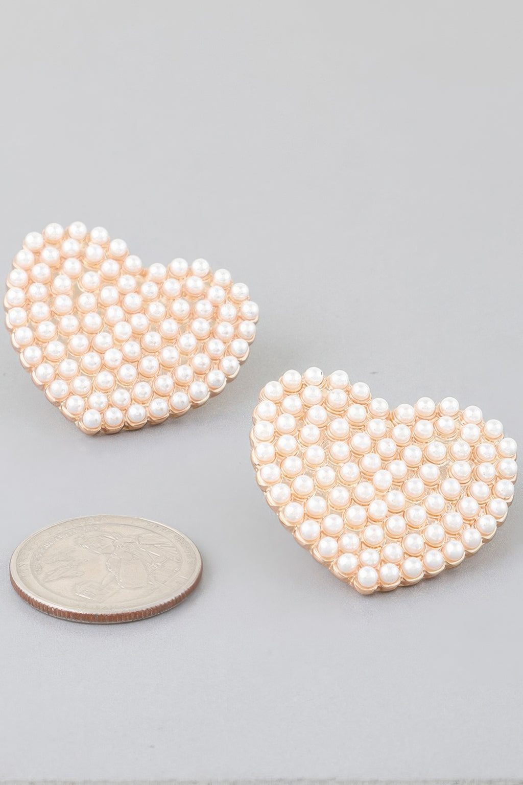 Pearled heart stud earrings with cream pearls, gold-tone edges—pair shown