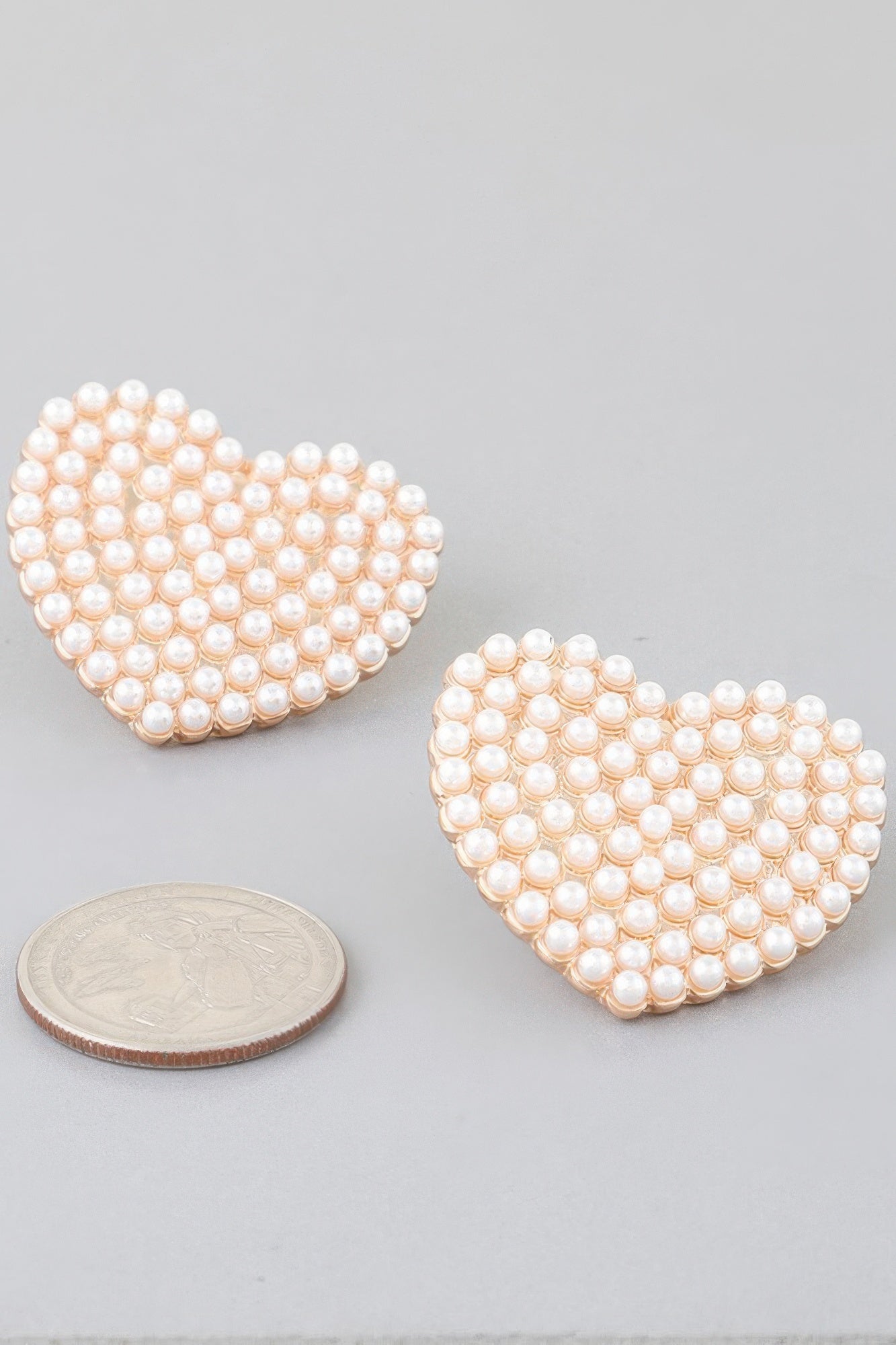 Pearled heart stud earrings with cream pearls, gold-tone edges—pair shown