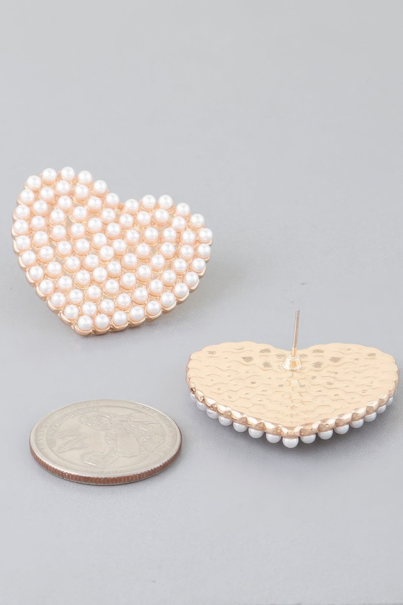 Cream pearl heart stud earring on gold-tone stud post, side view