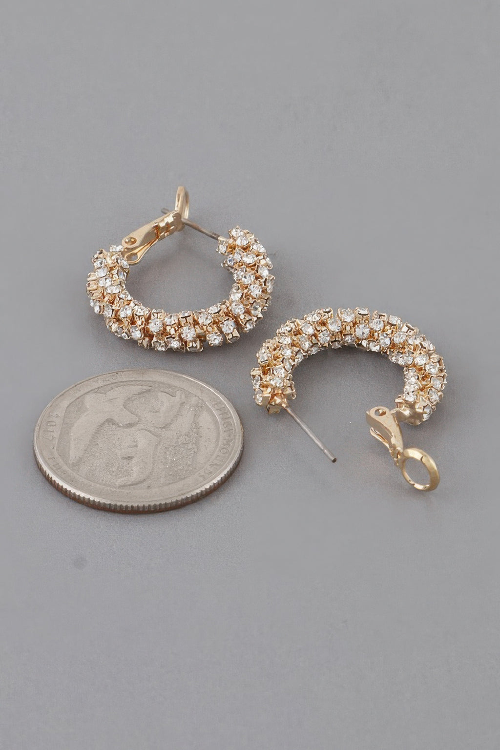 Gold bejeweled hoop earrings with crystal pavé band and hinged clip back