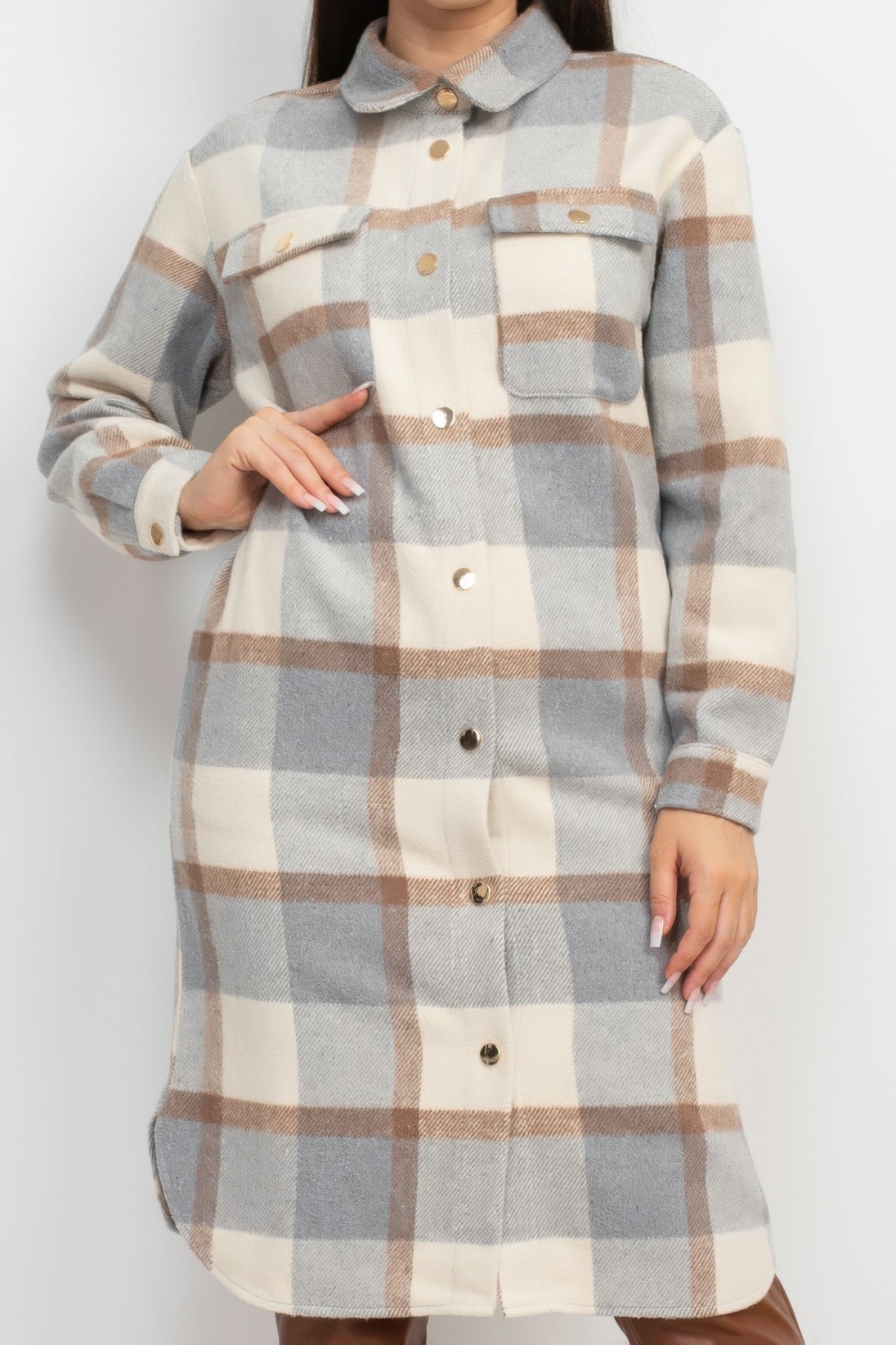 Close-up of cream/grey/tan plaid buttoned shacket coat with chest pockets and sleeve cuffs
