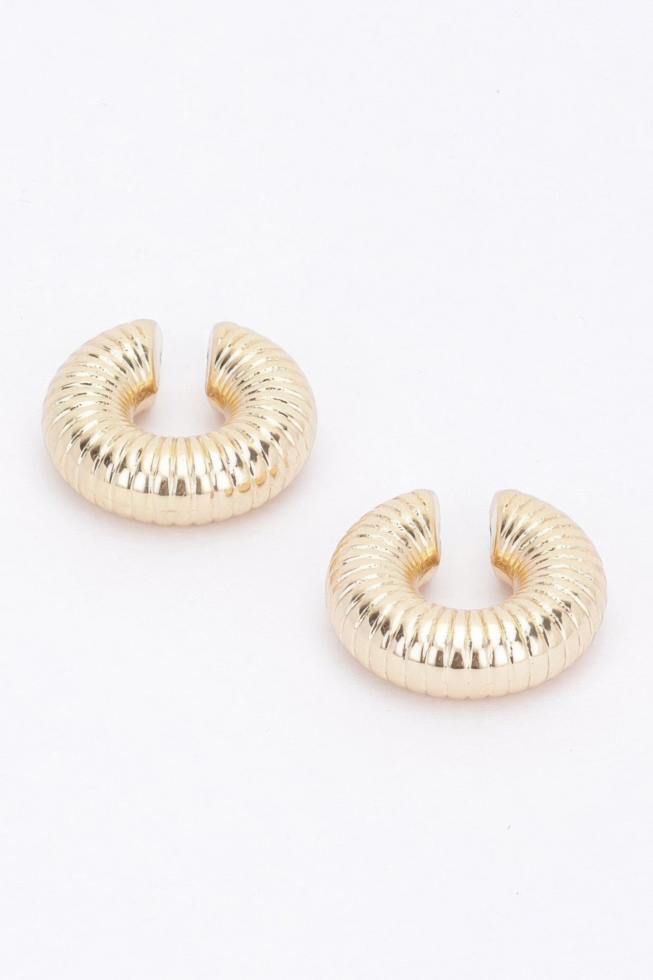 Gold-tone plastic cuff hoop earrings with ridged spiral design, set of two