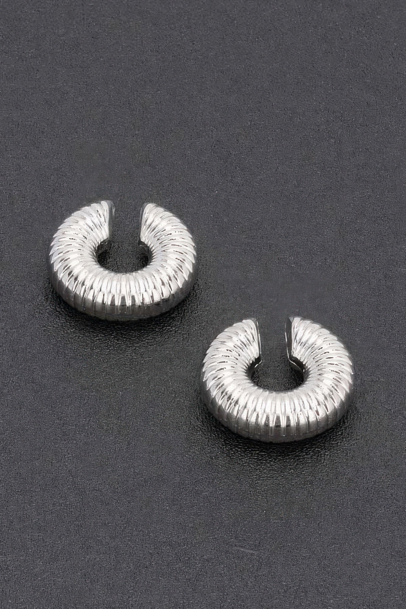 Silver-tone plastic cuff hoop earrings with textured ridged spiral, pair
