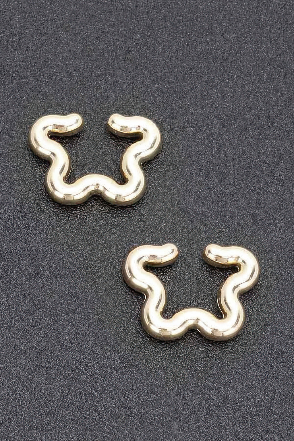 Gold plastic cuff earrings, wavy snake-shaped design