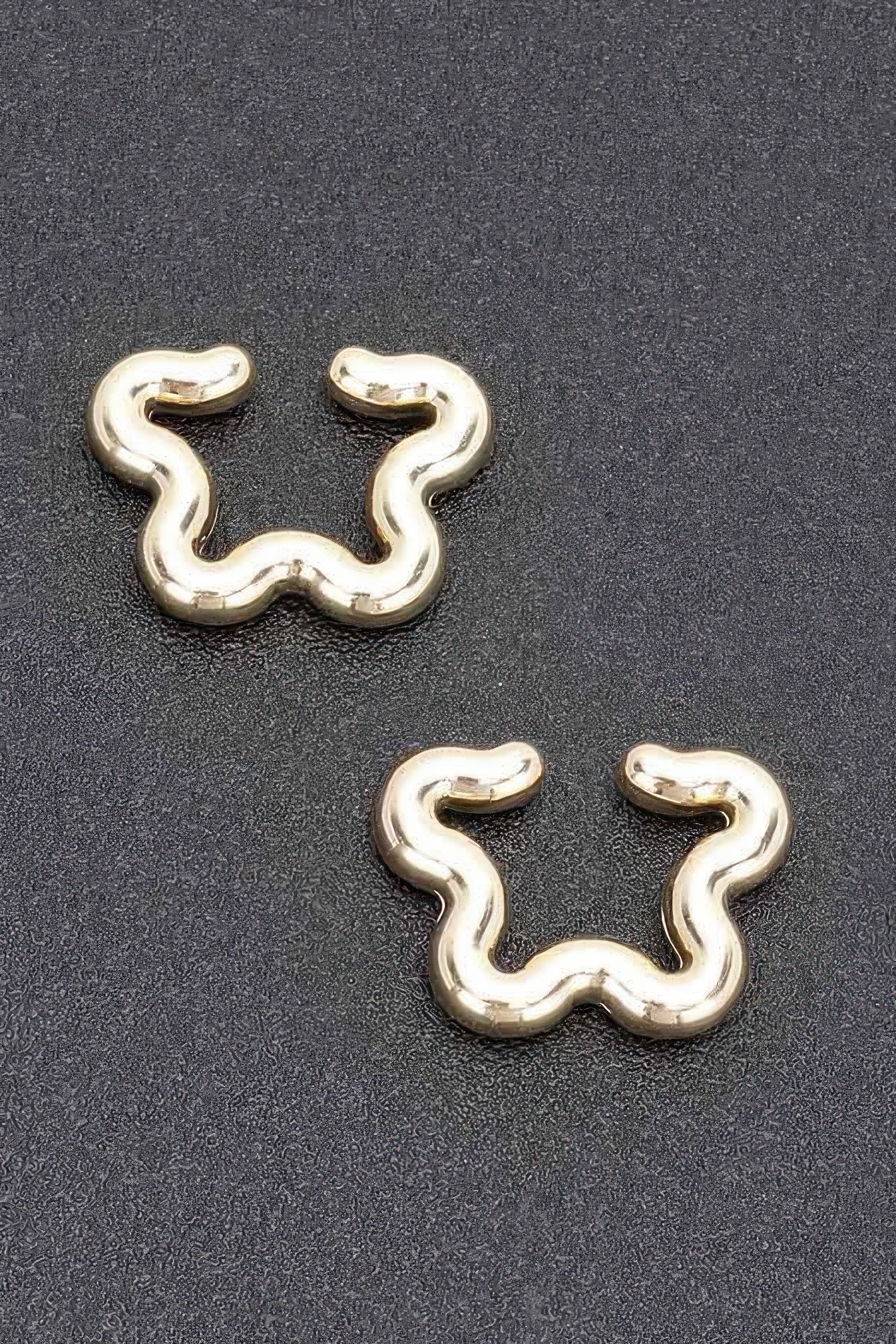 Gold plastic cuff earrings, wavy snake-shaped design