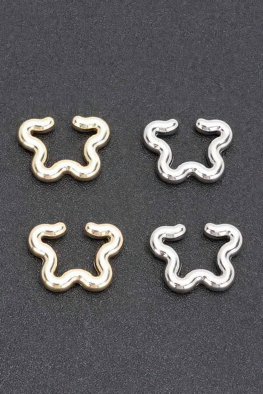 Plastic cuff earrings set: gold and silver pairs with wavy snake-shaped design
