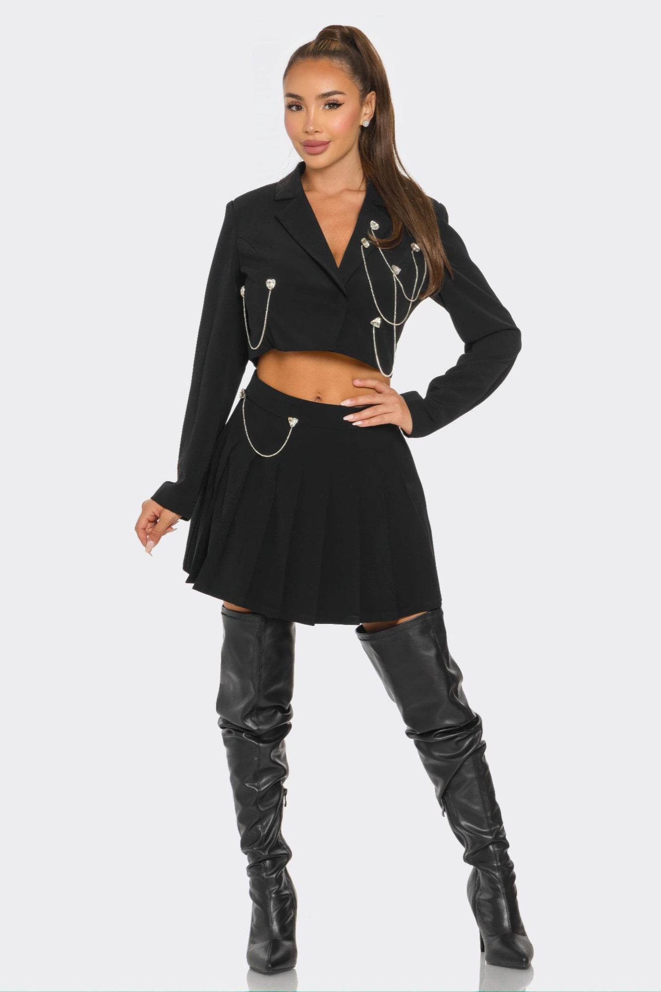 Black pleated mini skirt set with cropped blazer, chain detailing, flared pleats