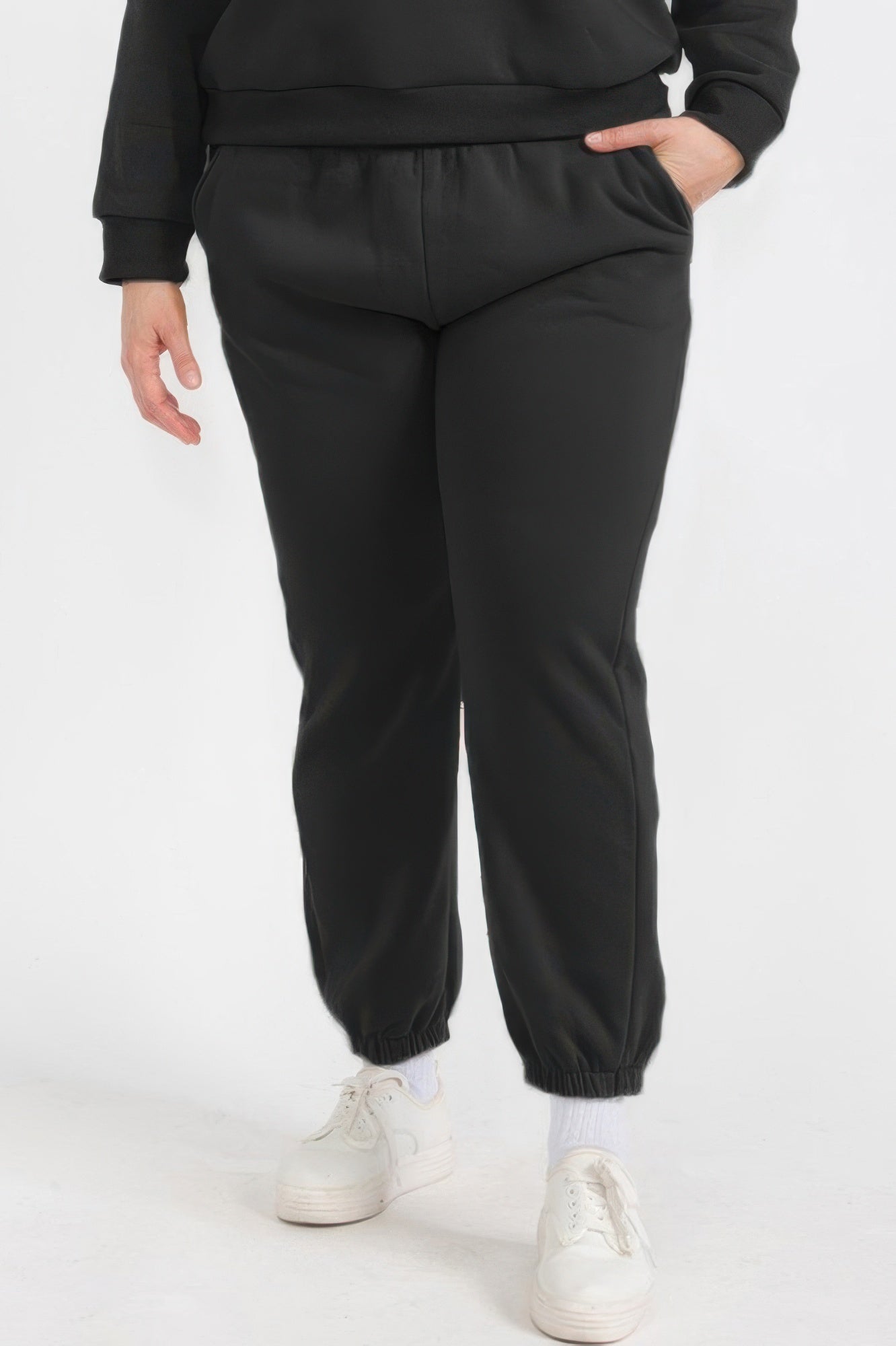 Plus size poly fleece joggers in black with elastic waistband and cuffed ankles