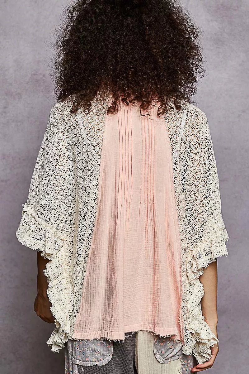 Back view of baby pink button-down shirt with pleated yoke and crochet patch sleeves