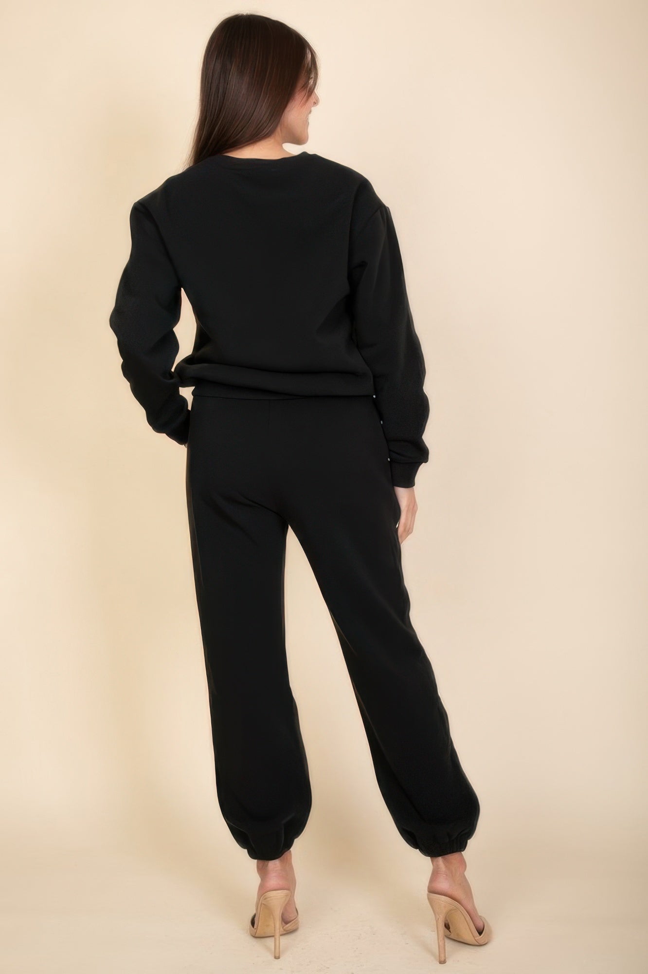 Black poly fleece joggers from back view, elastic waist and cuffed ankles