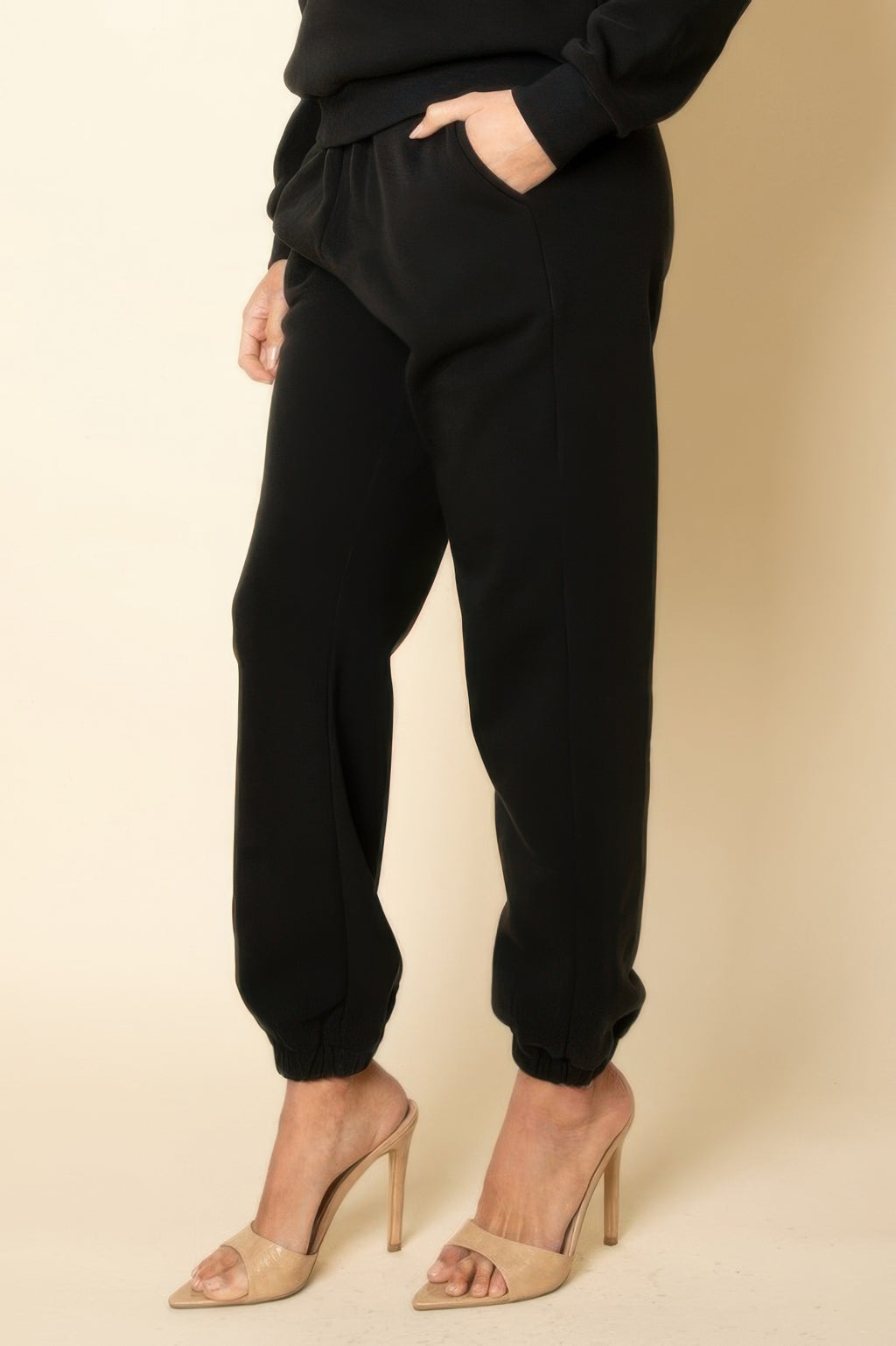Black joggers close-up at side seam, elastic cuffs and relaxed fit