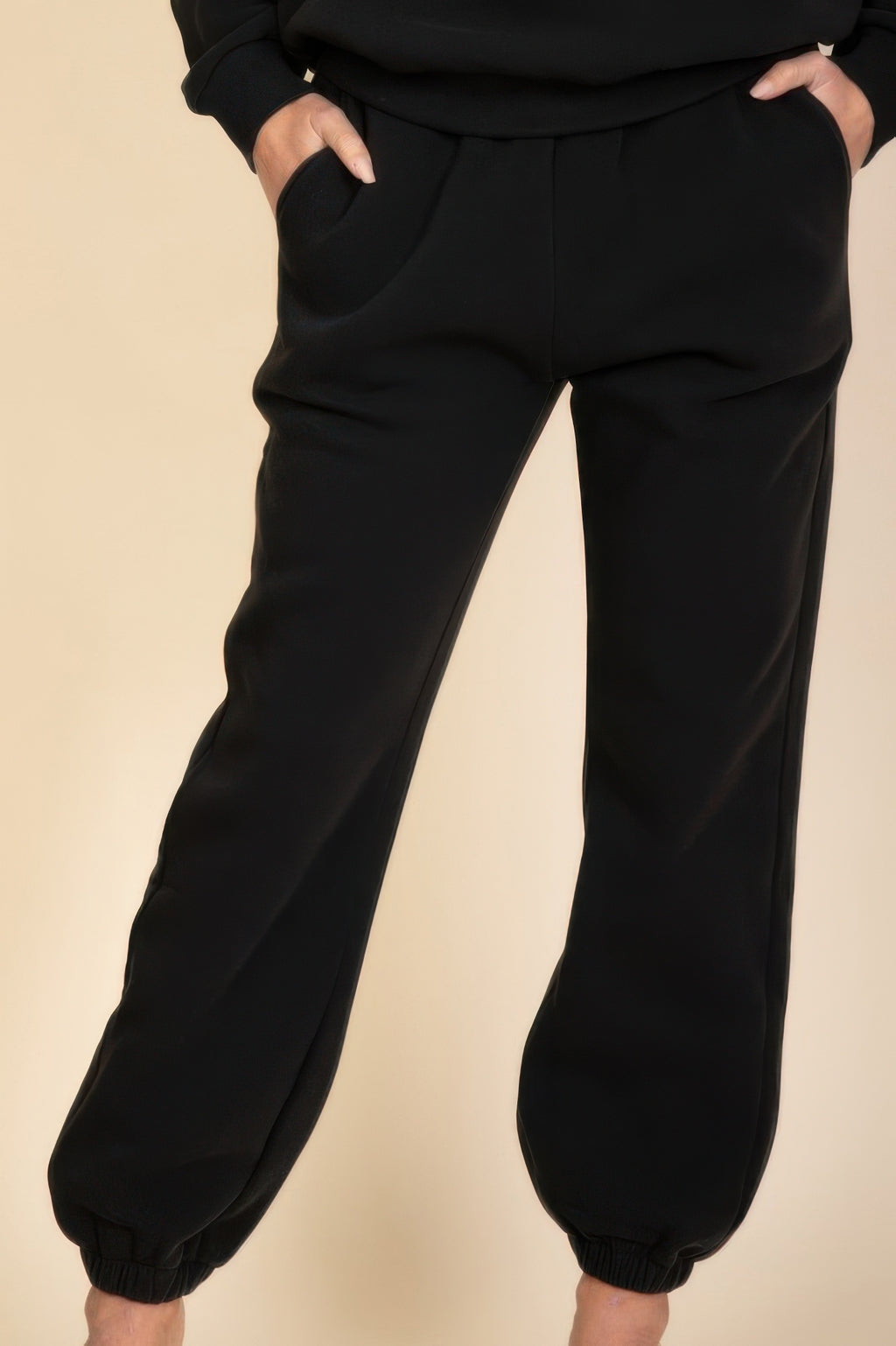Black poly fleece joggers front panel close-up, drawstring-free elastic ankle cuffs