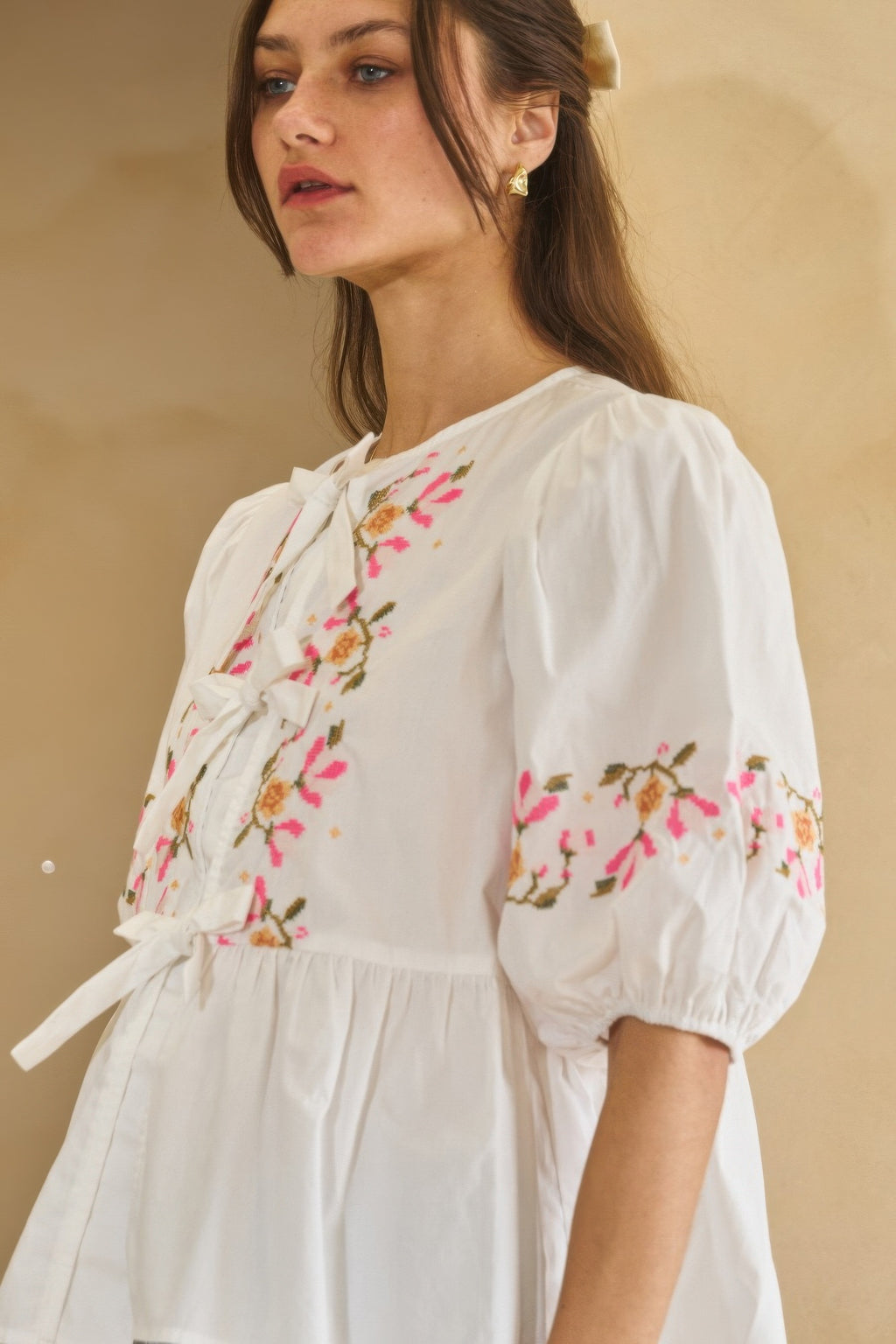 Close view of off-white poplin blouse front ribbon tie and embroidered florals