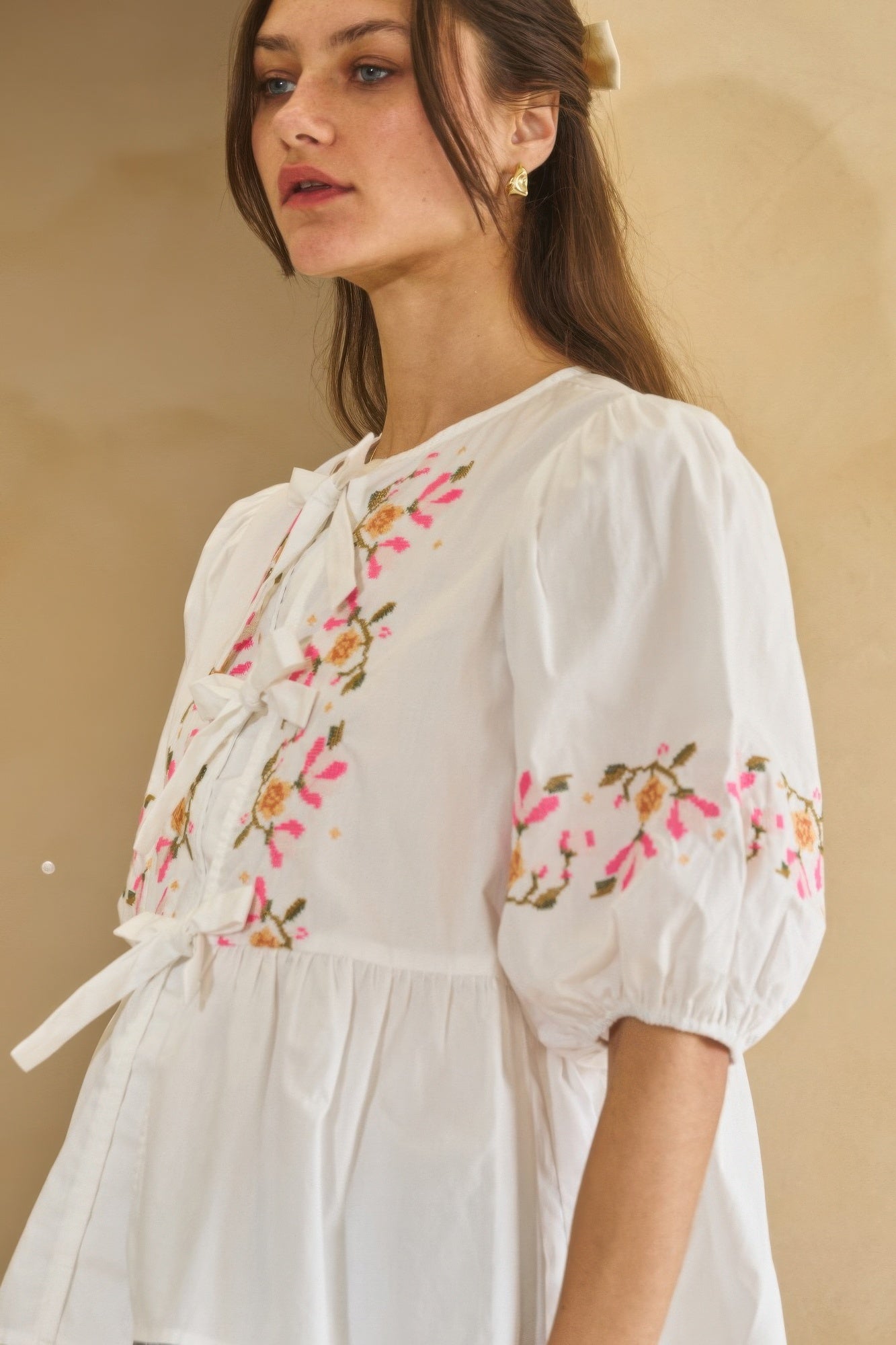 Close view of off-white poplin blouse front ribbon tie and embroidered florals
