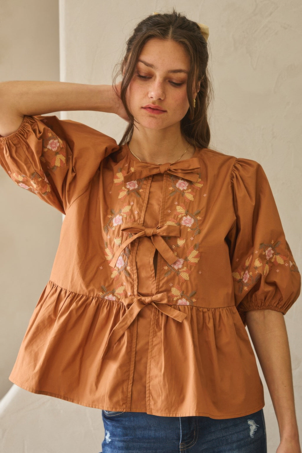 Chesnutt brown poplin blouse with bow tie neckline and floral puff sleeve details