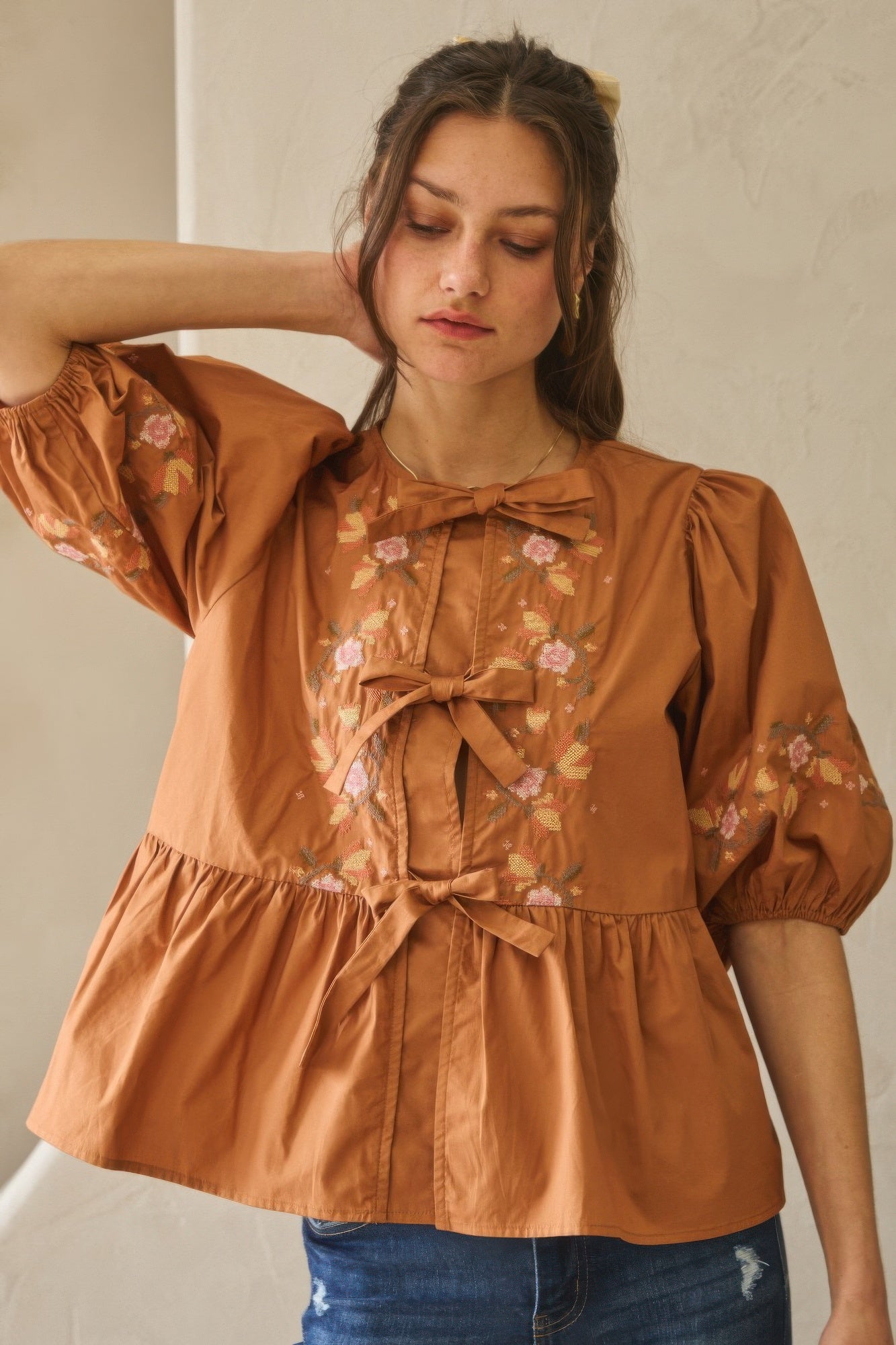 Chesnutt brown poplin blouse with bow tie neckline and floral puff sleeve details