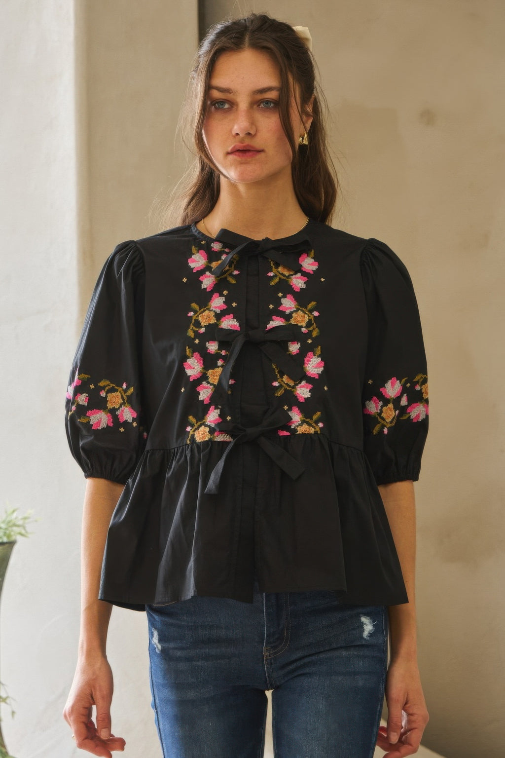 Black poplin blouse with front ribbon tie and colorful floral embroidery on sleeves