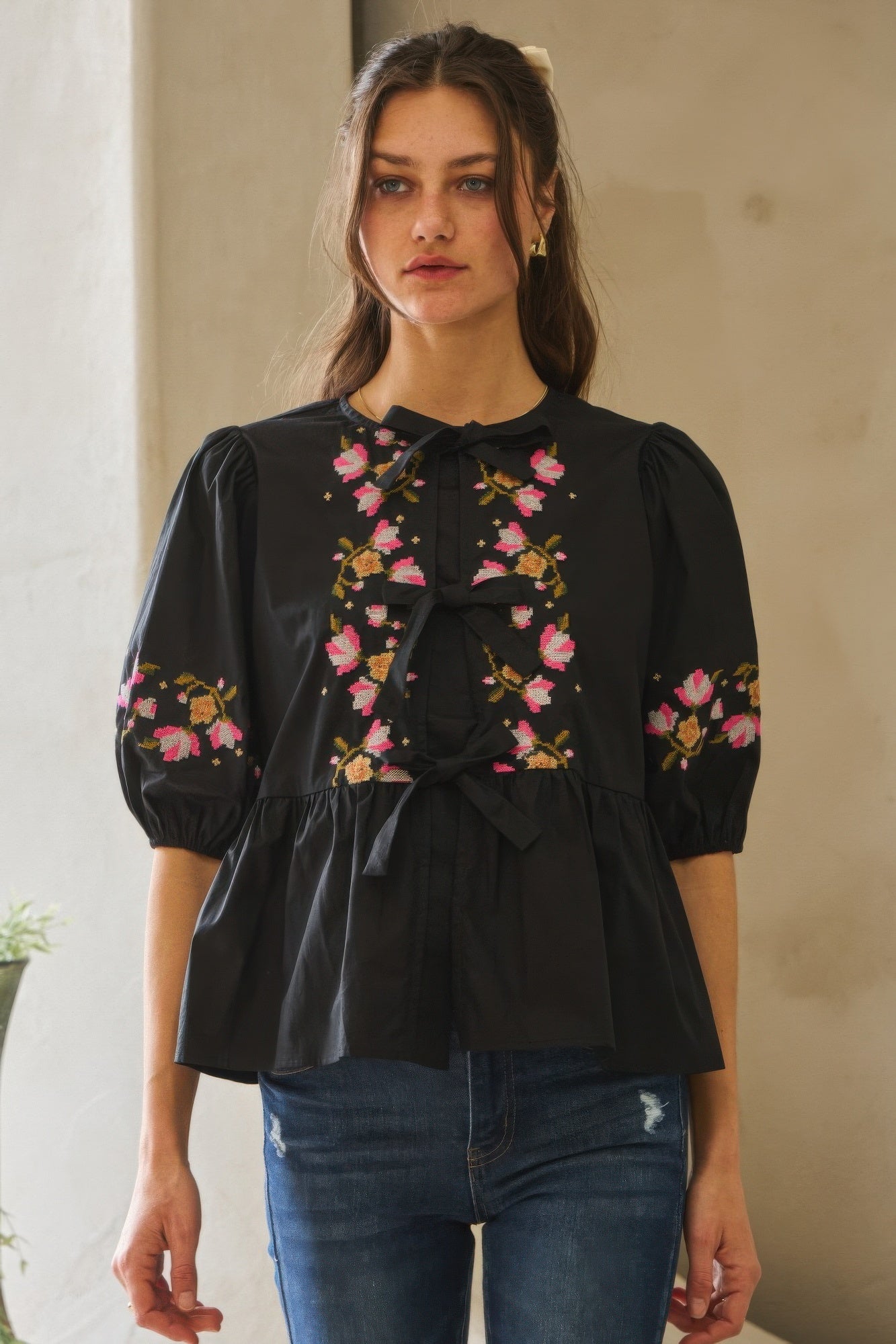 Black poplin blouse with front ribbon tie and colorful floral embroidery on sleeves
