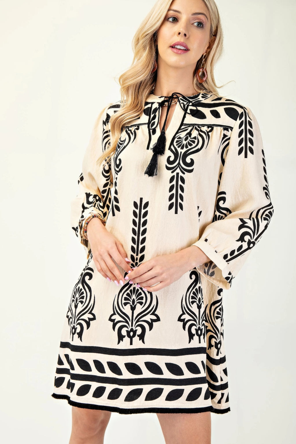 Printed 3/4 sleeve dress in cream with black tassel tie and fringed hem detail