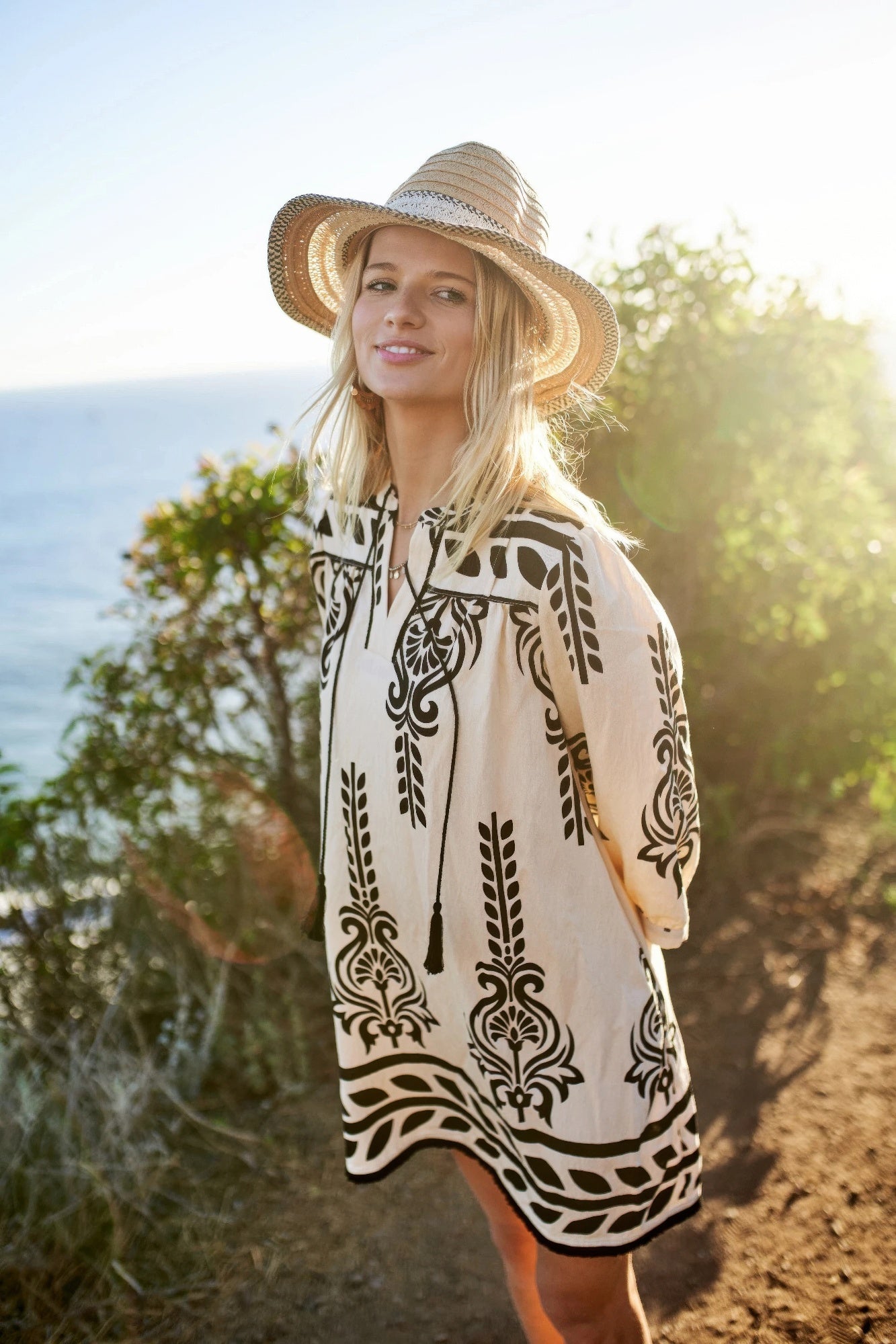 Printed cream tunic dress with black patterns and tassel neckline tie