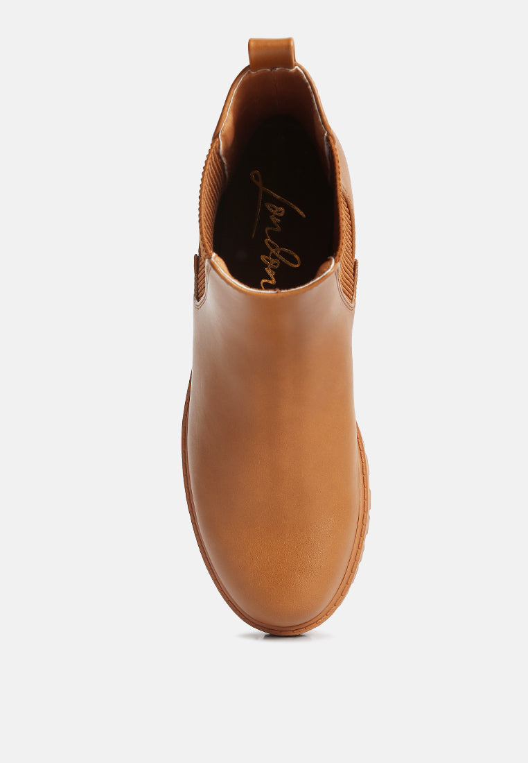 Tan Chelsea ankle boot showing pull-on heel opening and stitched leather upper