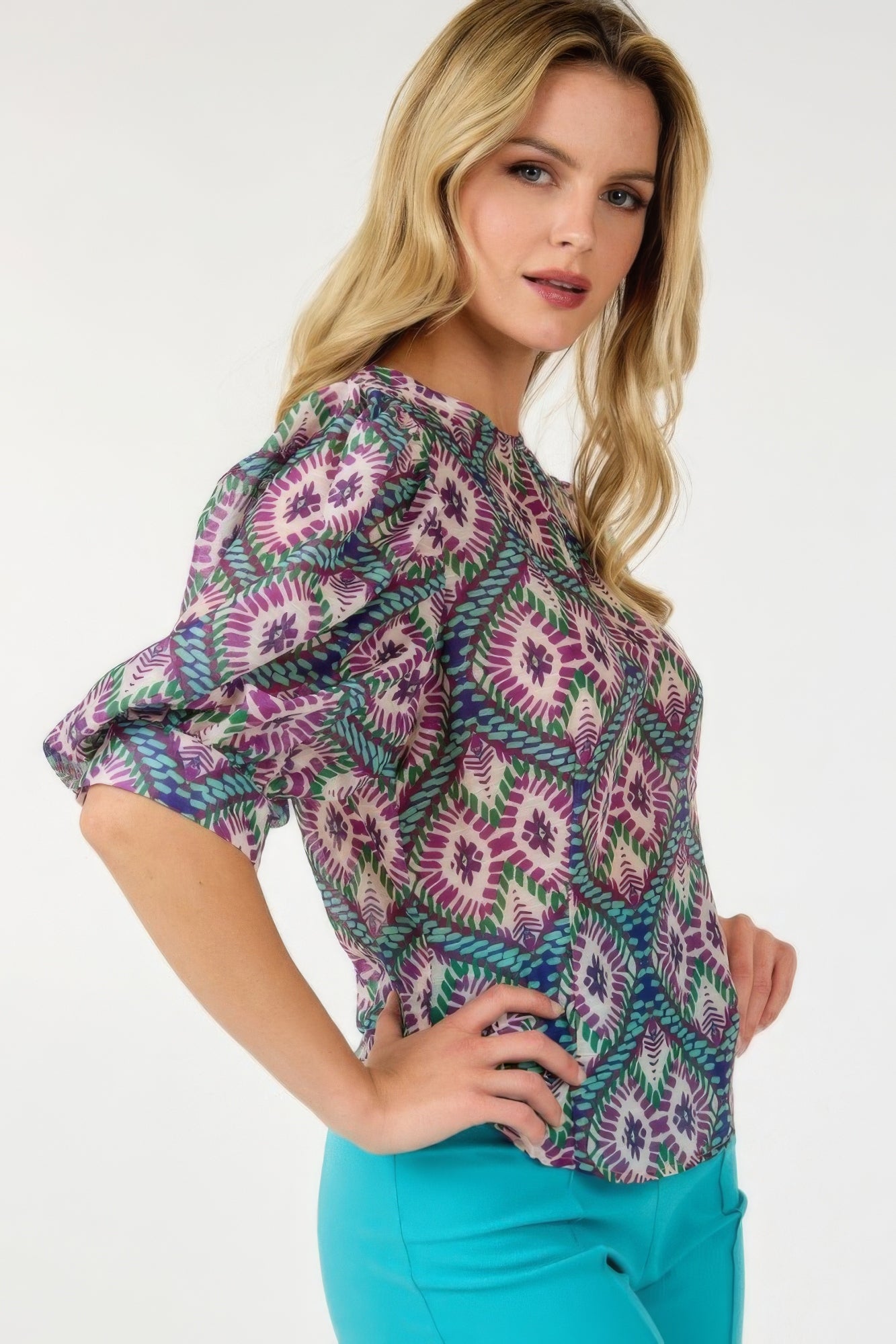 Side view of puff sleeve multi-print top with purple, green and teal pattern