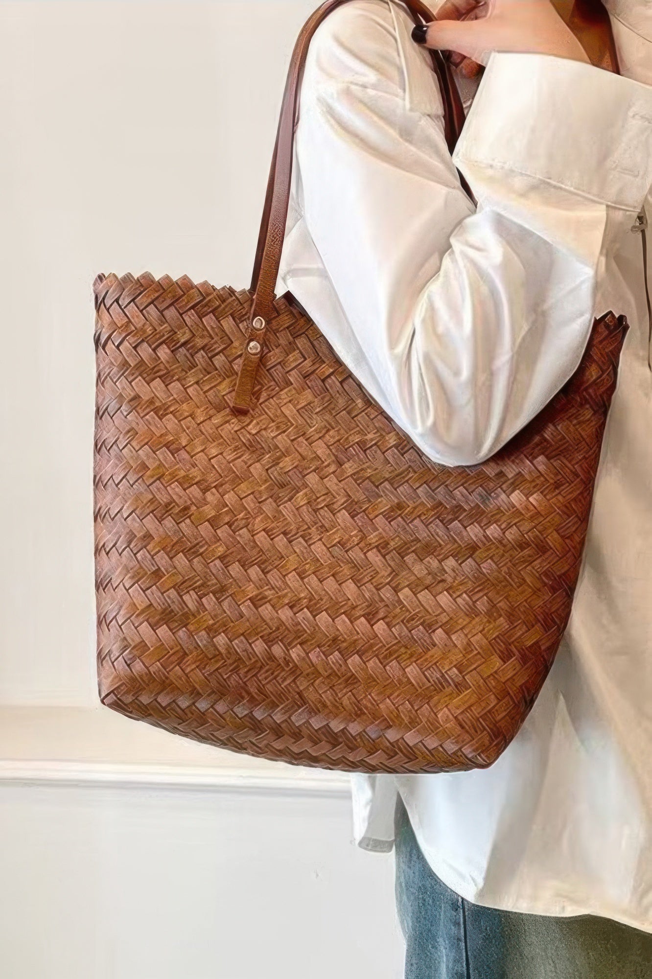 Brown PVC braided tote bag with short handles and snap-button strap details