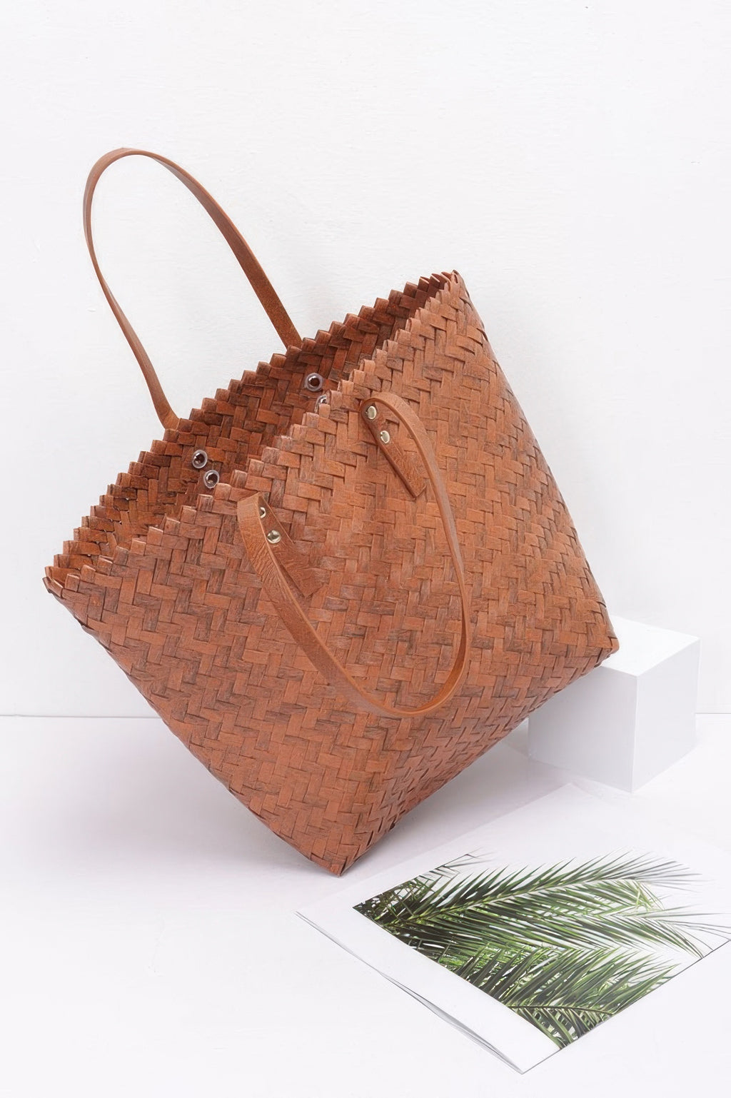Brown woven-style PVC tote with two shoulder straps, metal eyelet buttons