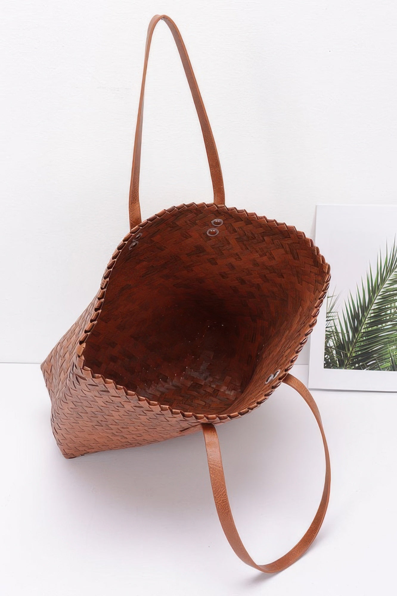 Dark brown PVC braided tote with single long handle and snap-button top