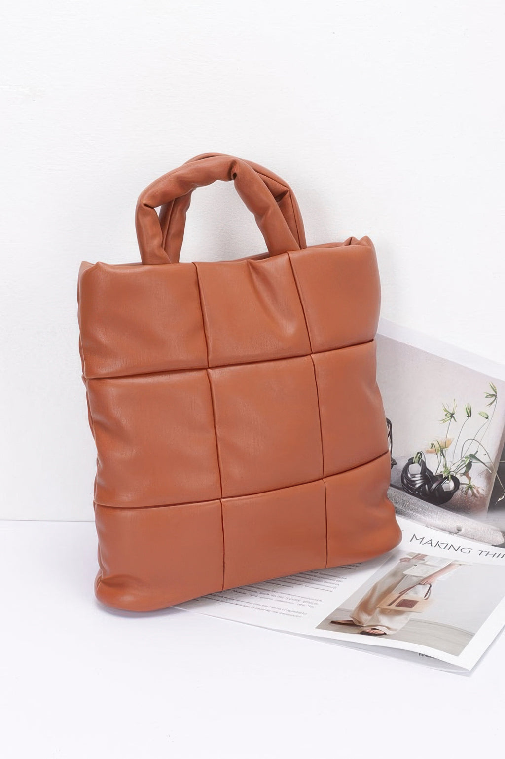Camel quilted tote bag side view with top handles and structured padded shape