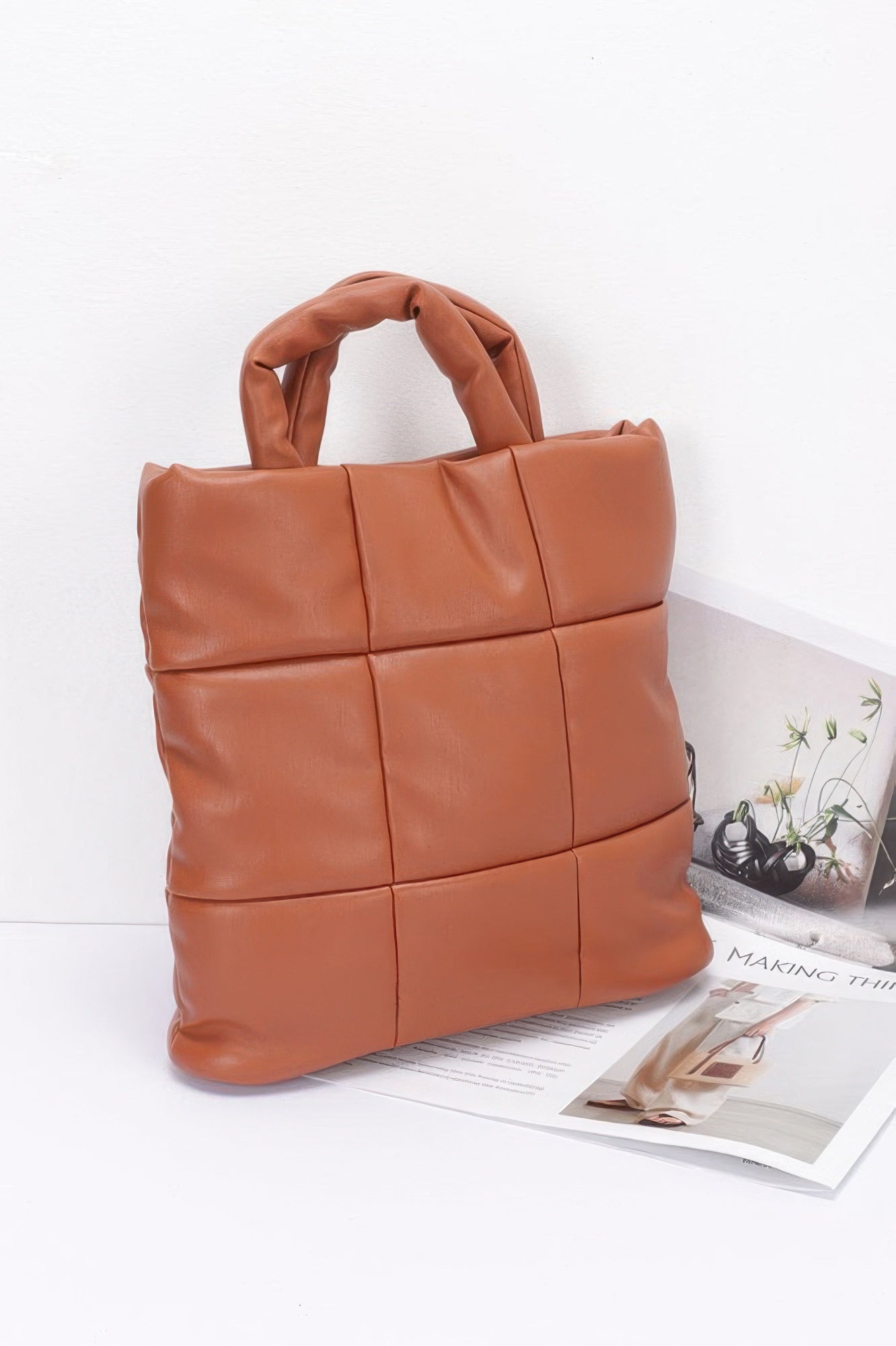Camel quilted tote bag side view with top handles and structured padded shape