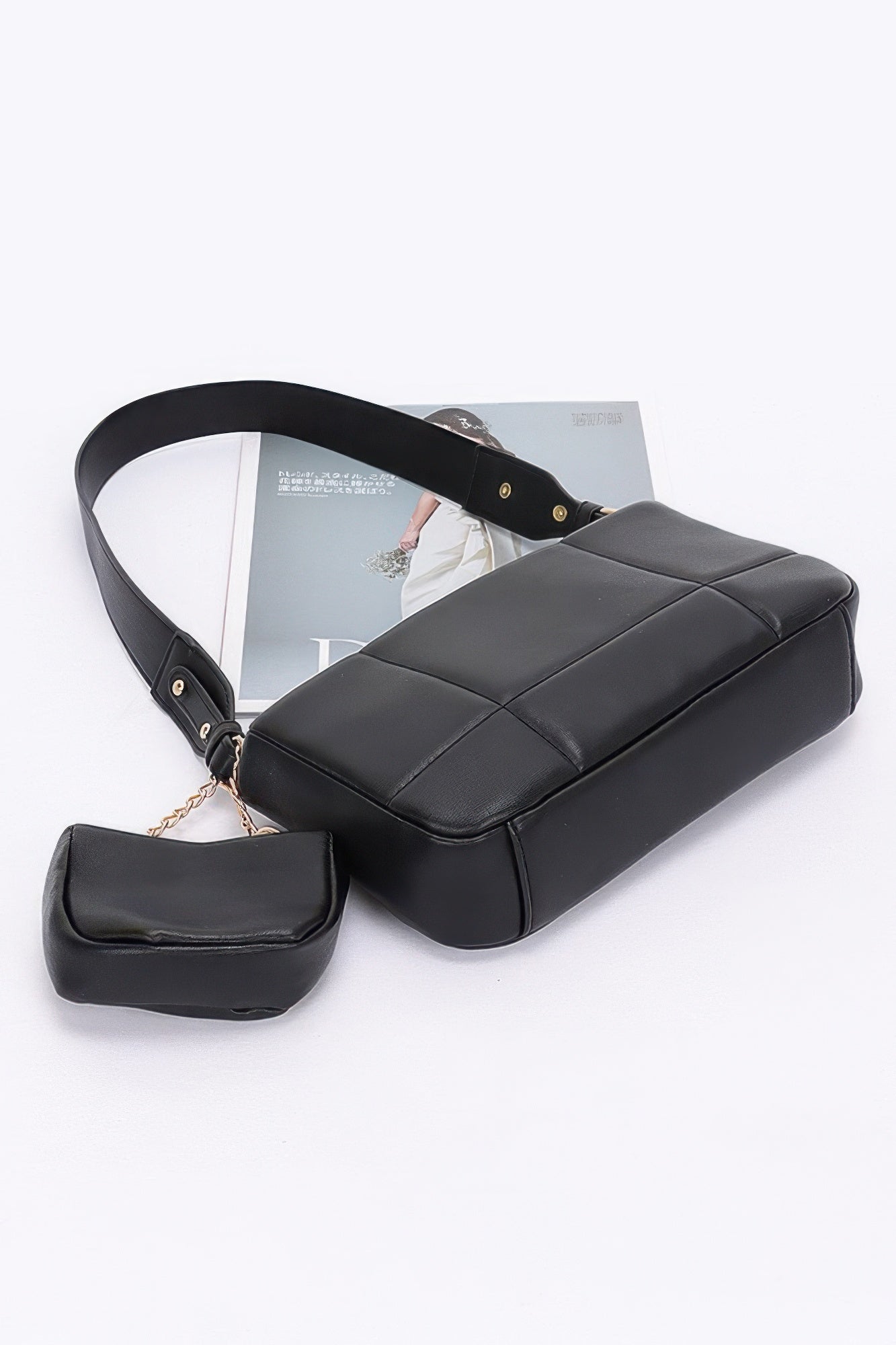 Black quilted bag with curved top handle, zip detail, and attached small AirPods pouch