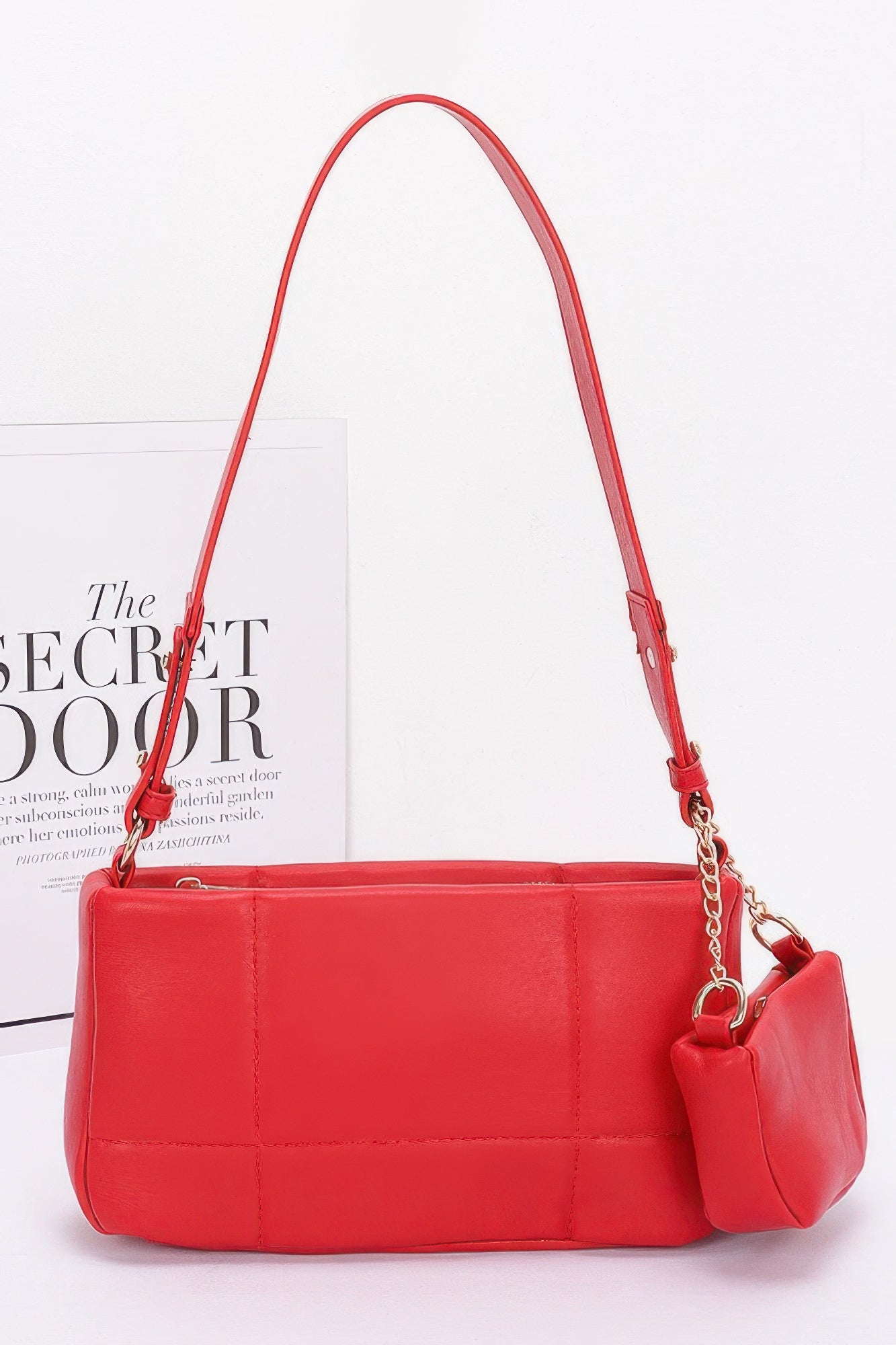 Red quilted faux leather shoulder bag with chain strap and small AirPods pouch