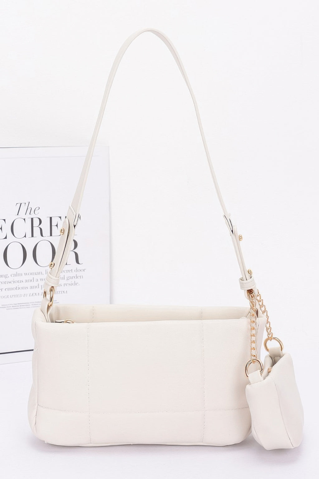 Ivory quilted shoulder bag with chain strap and attached small AirPods pouch