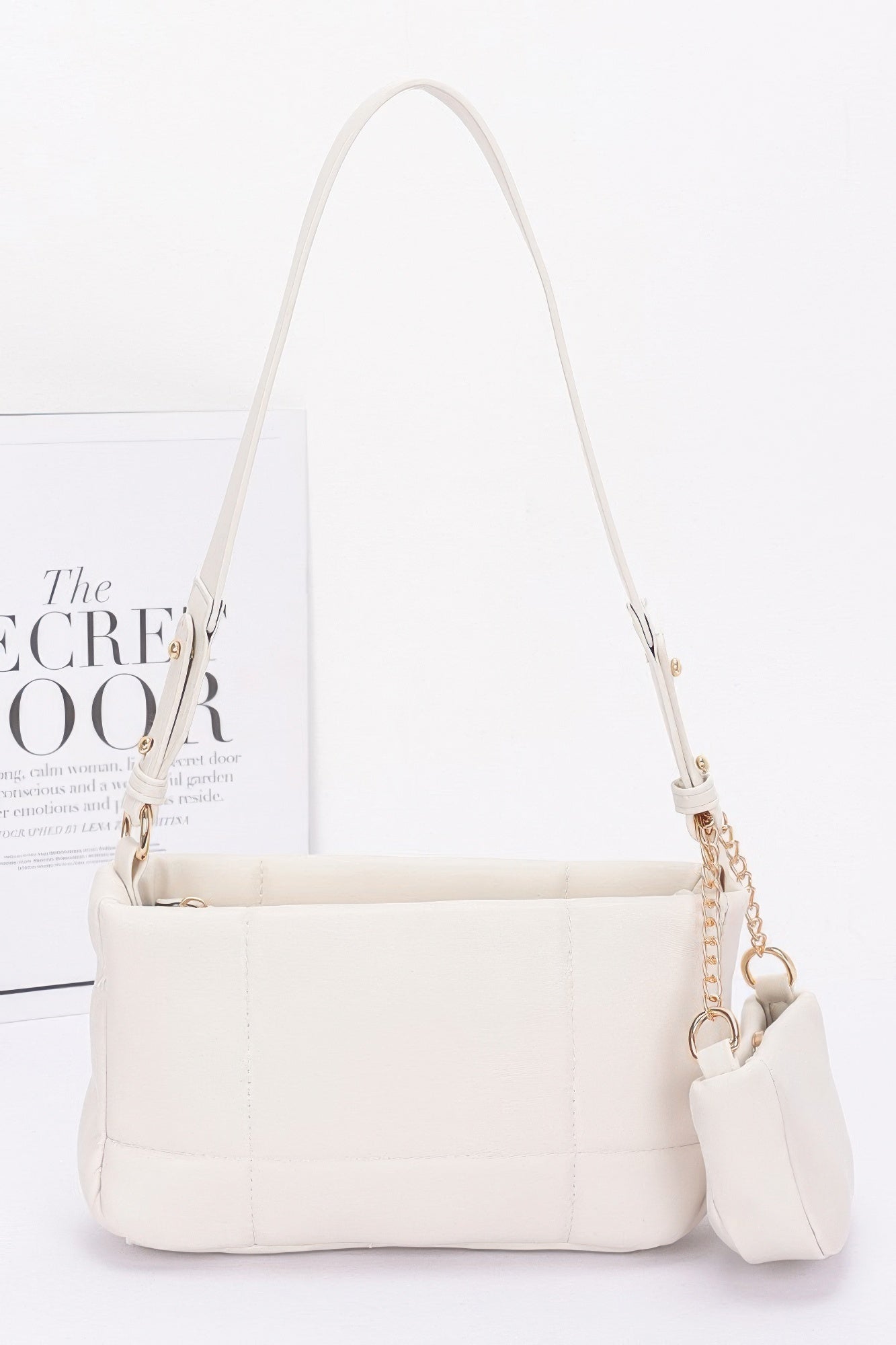 Ivory quilted shoulder bag with chain strap and attached small AirPods pouch