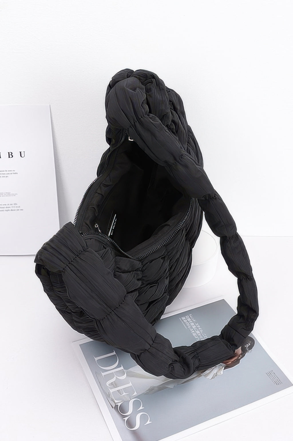 Black quilted nylon padded crossbody bag with zip top and interior pocket