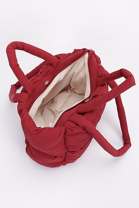 Burgundy puffer tote bag with open top showing light inner lining and zipper closure