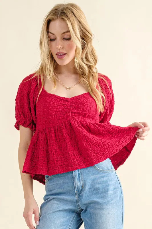 Red textured smocked peplum top with square neckline and puff sleeves