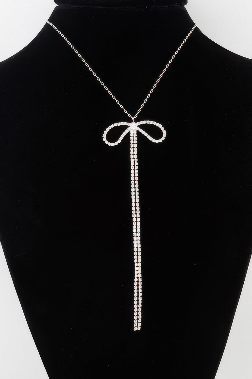 Rhinestone bow necklace: silver-tone chain with long clear rhinestone drops.
