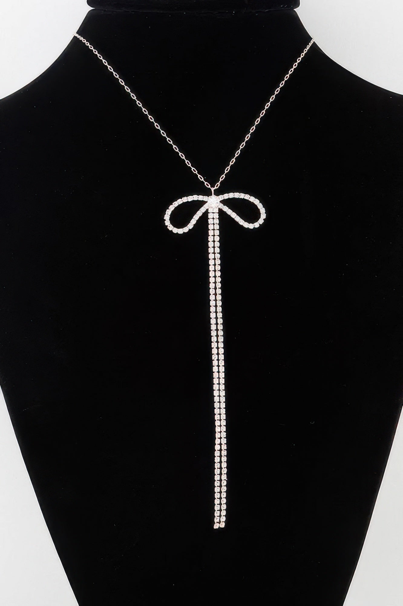 Rhinestone bow necklace: silver-tone chain with long clear rhinestone drops.