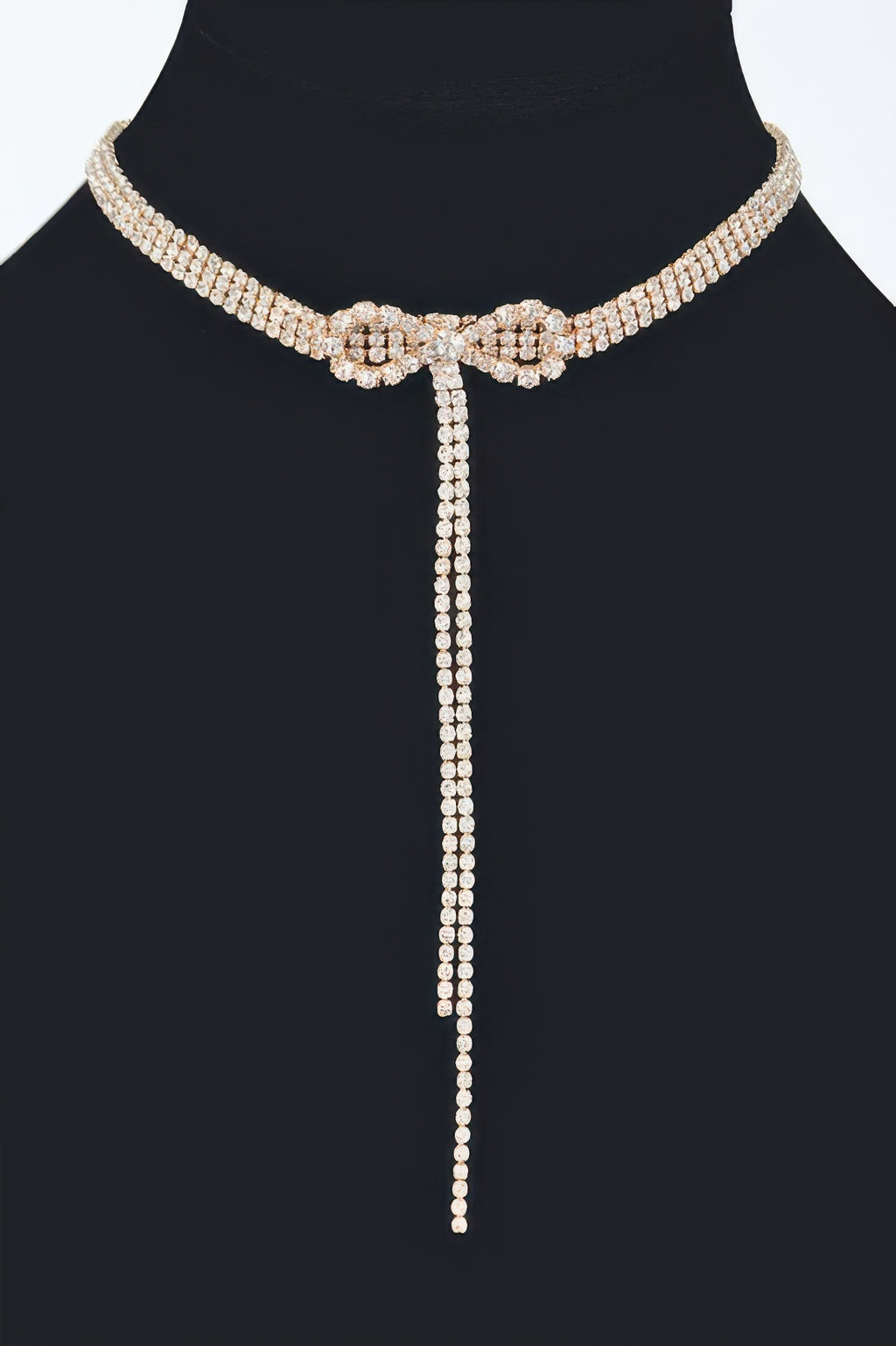 Rhinestone bow string choker with long dangling tail, gold-tone